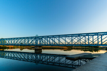 Former train tracks turned bridge named Den Blå Bro at night between golden and blue hour sunset over the Gudenå river in Randers Denmark