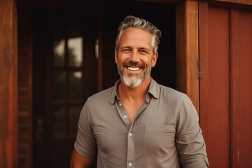Portrait of a handsome middle-aged man smiling while standing outside. - obrazy, fototapety, plakaty