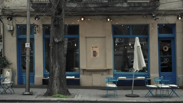 Static shot of the outside empty terrace of a bar with a blue and white theme design on an overcast day