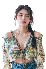 Portrait of a pretty young woman super model of Chinese ethnicity wearing a boho-inspired peasant blouse with embroidered details, paired with distressed denim shorts and ankle boots
