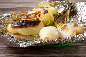 A view of grilled spring onions and yellow chiles.