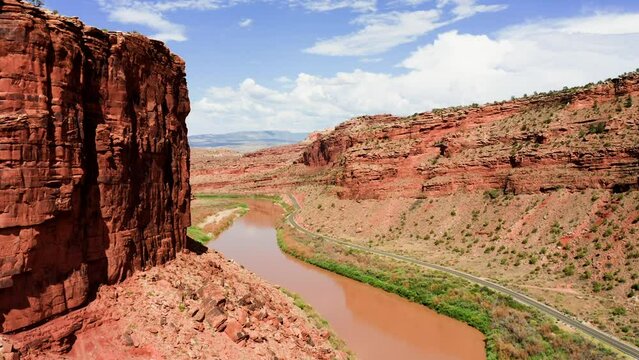 Flight up muddy Colorado River through craggy gorge on sunny day as it makes it way to the Grand Canyon.