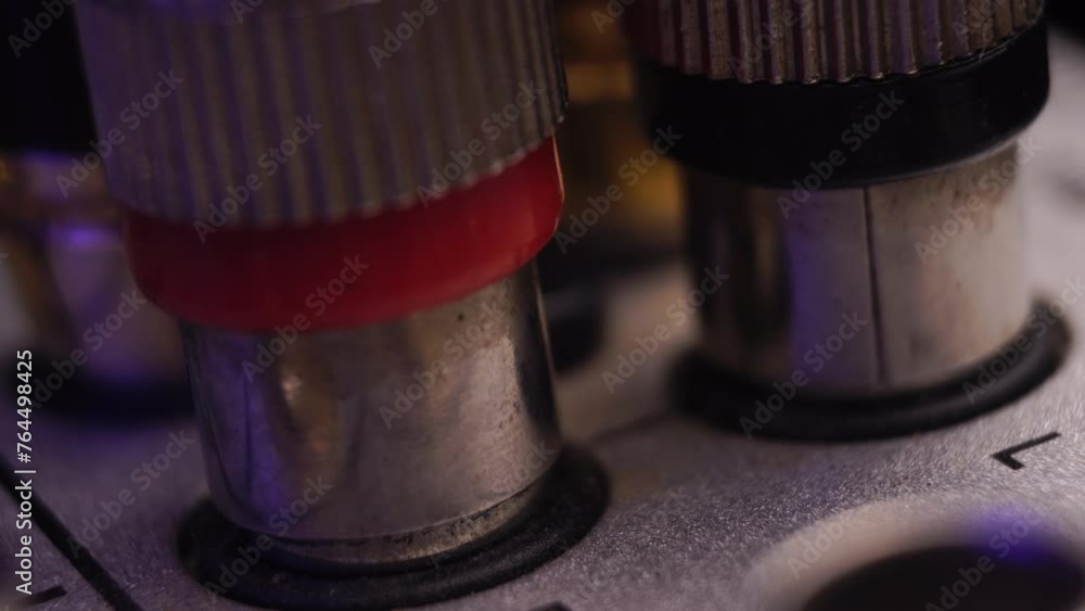 Poster connecting rca audio cable with input connectors on mixing console, macro close up