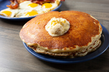 A view of a stack of pancakes, with a dollop of melting butter spread.