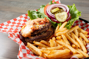 A view of a double cheeseburger with french fries.