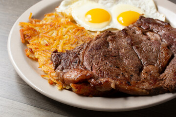 A view of a breakfast plate of steak and eggs.