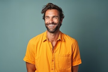 Portrait of a handsome man smiling at the camera over blue background - obrazy, fototapety, plakaty