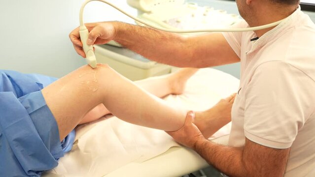 Physiotherapists perform Ultrasound therapy on the knee of a person
