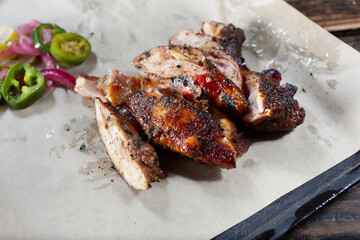 A view of a pile of smoked chicken on a tray.