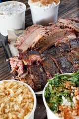 A view of a tray of assorted smoked meats and sides.