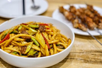 Goshilik lagman, a Uyghur dish of fresh handmade noodles stir-fried with meat and vegetables with a...