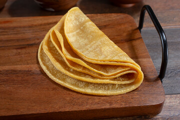 A view of a stack of folded warmed corn tortillas.
