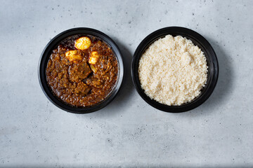 A top down view of a bowl of Ayamase stew, with a side of rice.