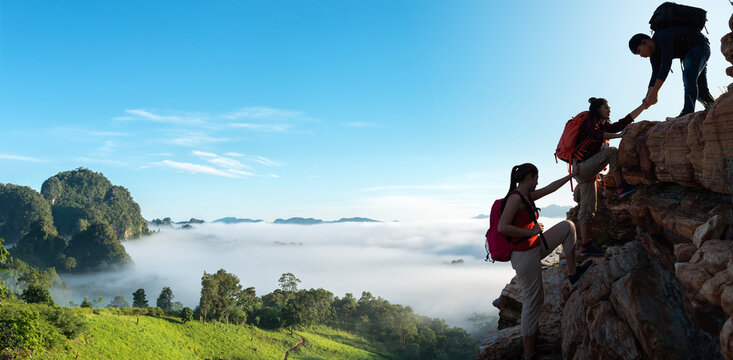 Asian hiking help each other on mountains