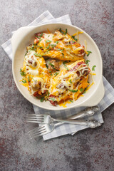 Alice Springs Chicken is a yummy cheesy, bacon and mushroom, delicious hot mess closeup in the baking dish on the table. Vertical top view from above
