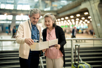 Grandpa and Grandma checking map before travel in international airport