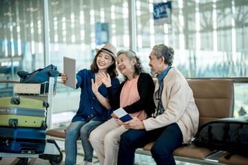 Happy family using digital tablet for video conference and waving hand. focus Young woman and Grandma smiling using digital tablet for video call with nephews or friends in international airport.