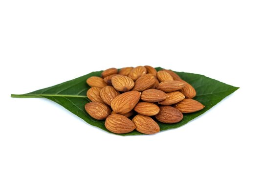 Closeup picture of almond put on leaf green color in white background ready for eat.concept isolate picture.organic of nuts with almond.