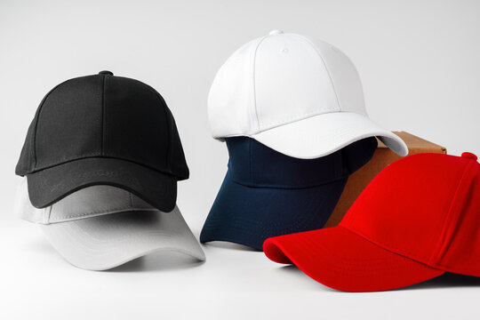Stack of Assorted Baseball Caps on a White Background