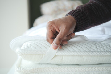 Placing the white sheet on the mattress for added comfort