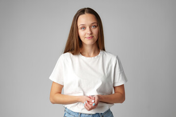 Portrait of a young woman in white T-shirt on gray background