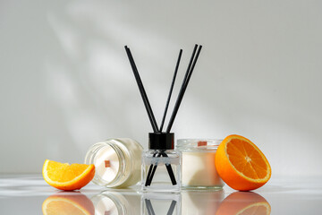 Elegant Aroma Diffuser With Black Reeds on a Slate Base Next to a Fresh Orange Slice