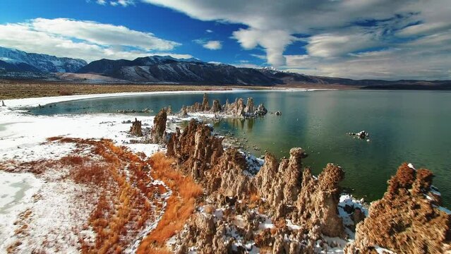 Aerial: Drone Forward Shot Of Rock Formations By Mono Lake During Snowy Weather - June Lake, California