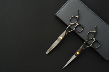 Hairdressing scissors with case on a black background