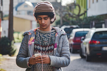 urban young man with headphones and phone on the street