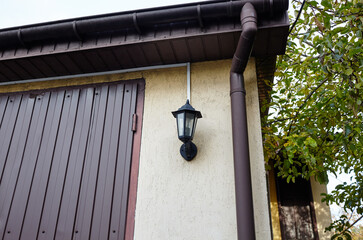 Facade of a suburban garage. Building with downspout and lantern
