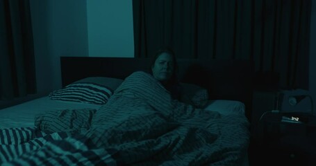 Wide view of woman waking up and stepping out of bed