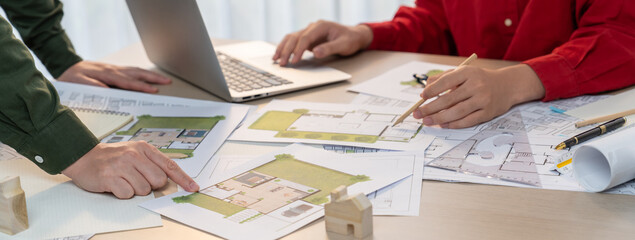A portrait of skillful architect discussing with his coworker about house construction design...
