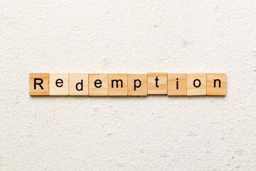 redemption word written on wood block. redemption text on cement table for your desing, concept