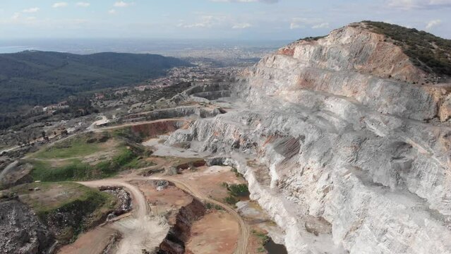 Aerial view towards huge quarry sunny day city background