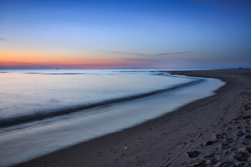 A beautiful sunset on the beach of the Sobieszewo Island at the Baltic Sea at spring. Poland - 764569000