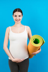 Pregnant Girl Holding Yoga Mat Standing Over Colored Background. Studio Shot, Free Space For Design