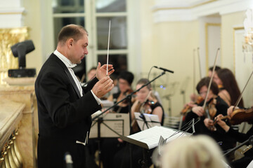 Conductor and musicians in classical symphony orchestra
