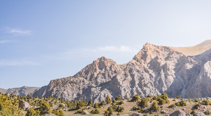 Racing landscape in the Fan Mountains with rocky slopes and vegetation in the morning in Tajikistan, Tien Shan highlands