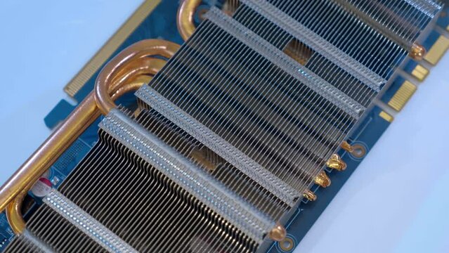 Powerful radiator with copper tubes for circulating coolant to cool the computer video card. Closeup. Macro. Shallow depth of field. Shot in motion