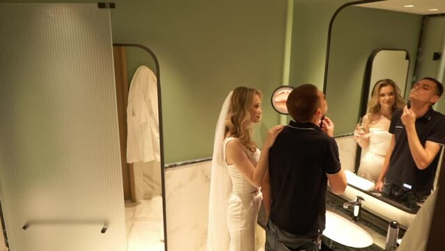 A photographer takes a picture of the morning of the bride and groom in bathroom