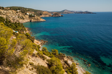 Turquoise waters and colorful trees in one of the most reserved and beautiful coves in Ibiza, Cala Llentrisca, Es Cubells, Sant Joan de Sa Talaia, Ibiza, Balearic Islands, Spain