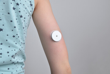 Child's hand with white sensor for continuous glucose monitoring. Concept of health, diabetes...