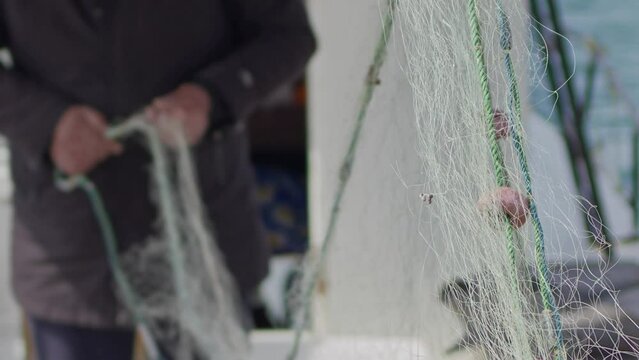 Fisherman Repairs Fishnets