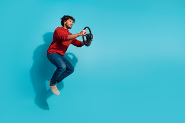 Obraz premium Full length photo of casual driver automobile young guy jumping with steering wheel advert taxi service isolated on blue color background