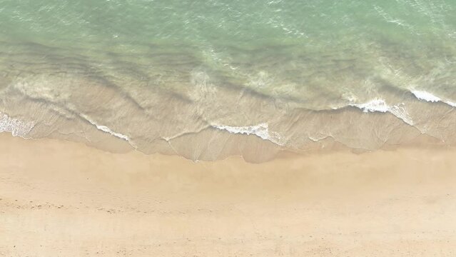 The soft wave water of the sea on the sandy beach background	