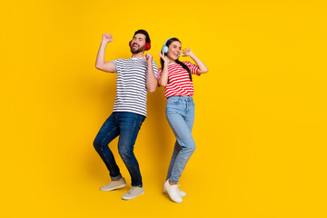 Full body portrait of two cheerful people enjoy music dancing empty space isolated on yellow color background