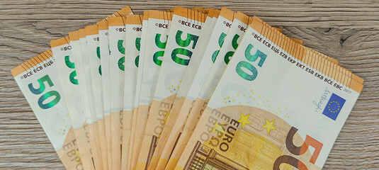 liasse de billets de banque de 50 euros, en gros plan, sur une table - obrazy, fototapety, plakaty