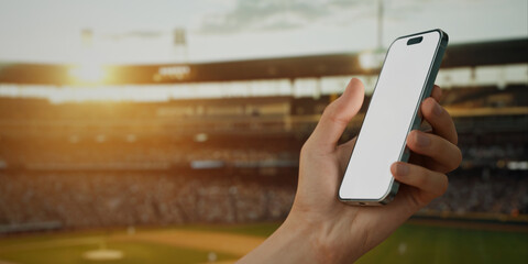 A hand holds a smartphone with a green screen at a baseball stadium - 764615643