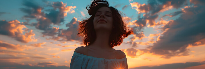 Young woman looking up at the sky at sunset