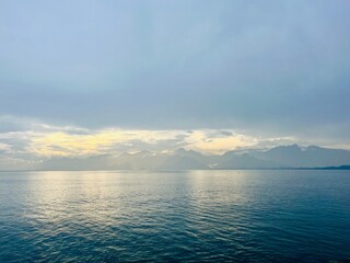 Fantastic seascape background, bright cloudy sky reflection on the blue sea surface, blue sea horizon background